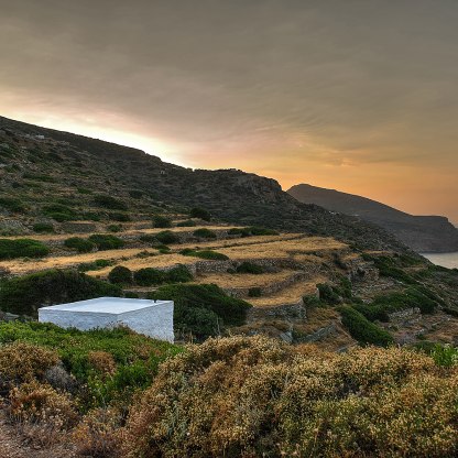 A highlight image for Island landscape showing terraces, a white stone building in the foreground and sunset