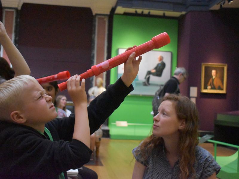 A boy looks through a telescope in the galleries.