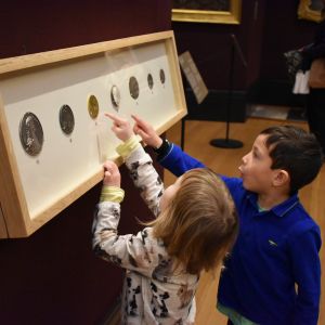 young children looking at coins in gallery 3